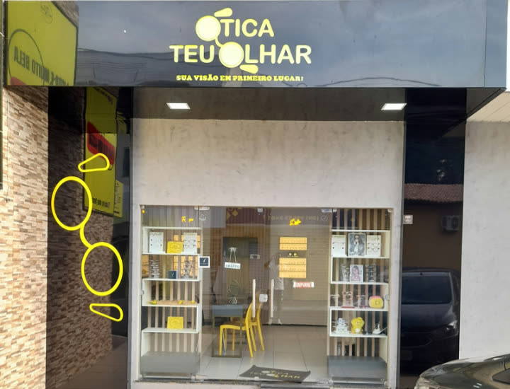 Fachada da matriz em Floriano, letreiro amarelo sobre toldo preto e vitrine com armações.